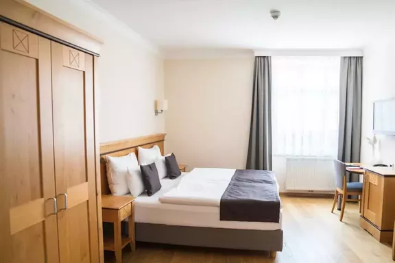 Hotel Schandl | Birgit Machtinger Doppelbett in einem Hotelzimmer im 1980er-Stil